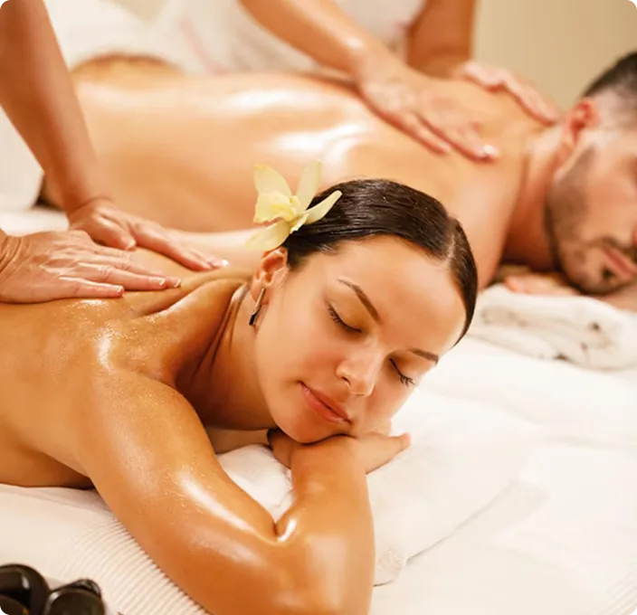 Relaxed client receiving back massage with orchid flowers
